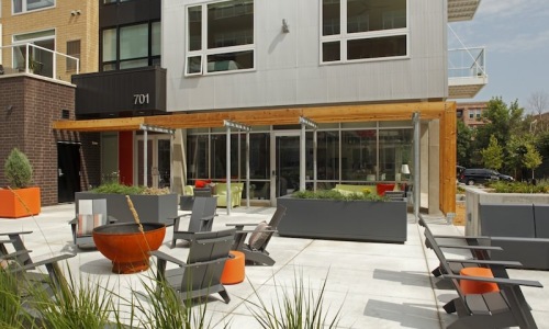 a courtyard with a fire pit and chairs