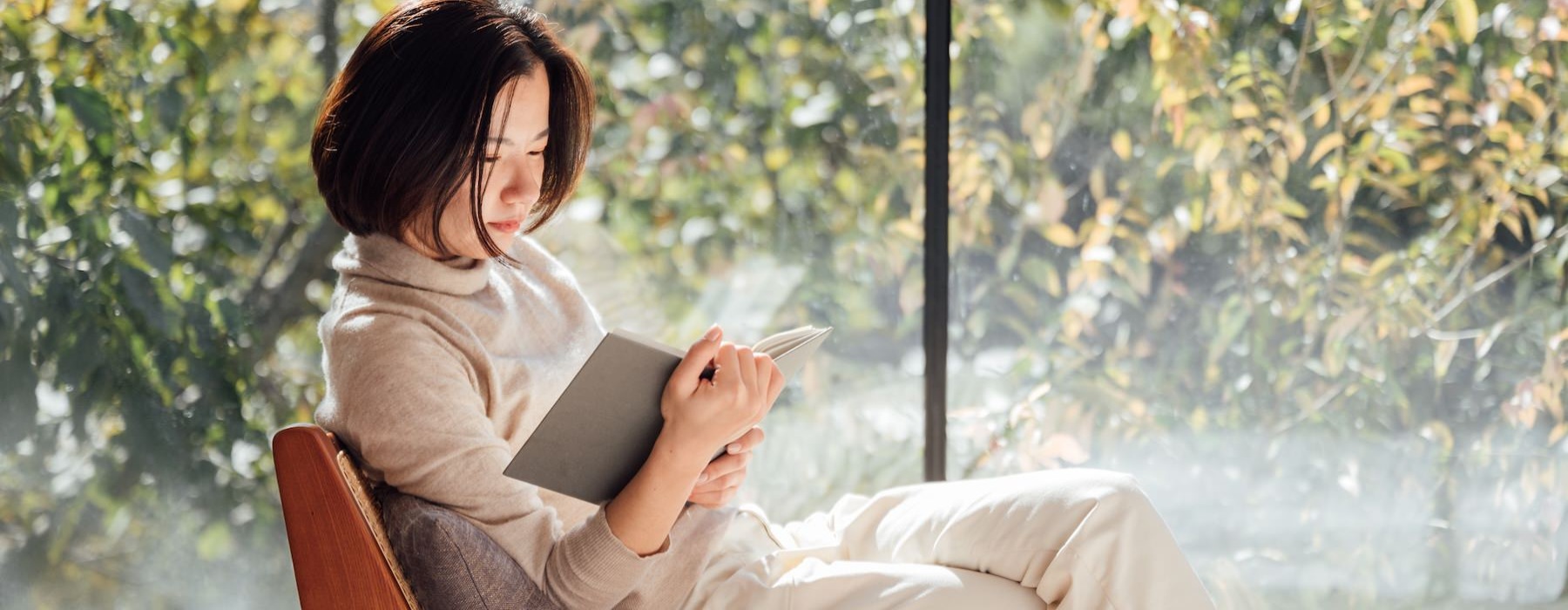 a woman sitting on a bench reading a book
